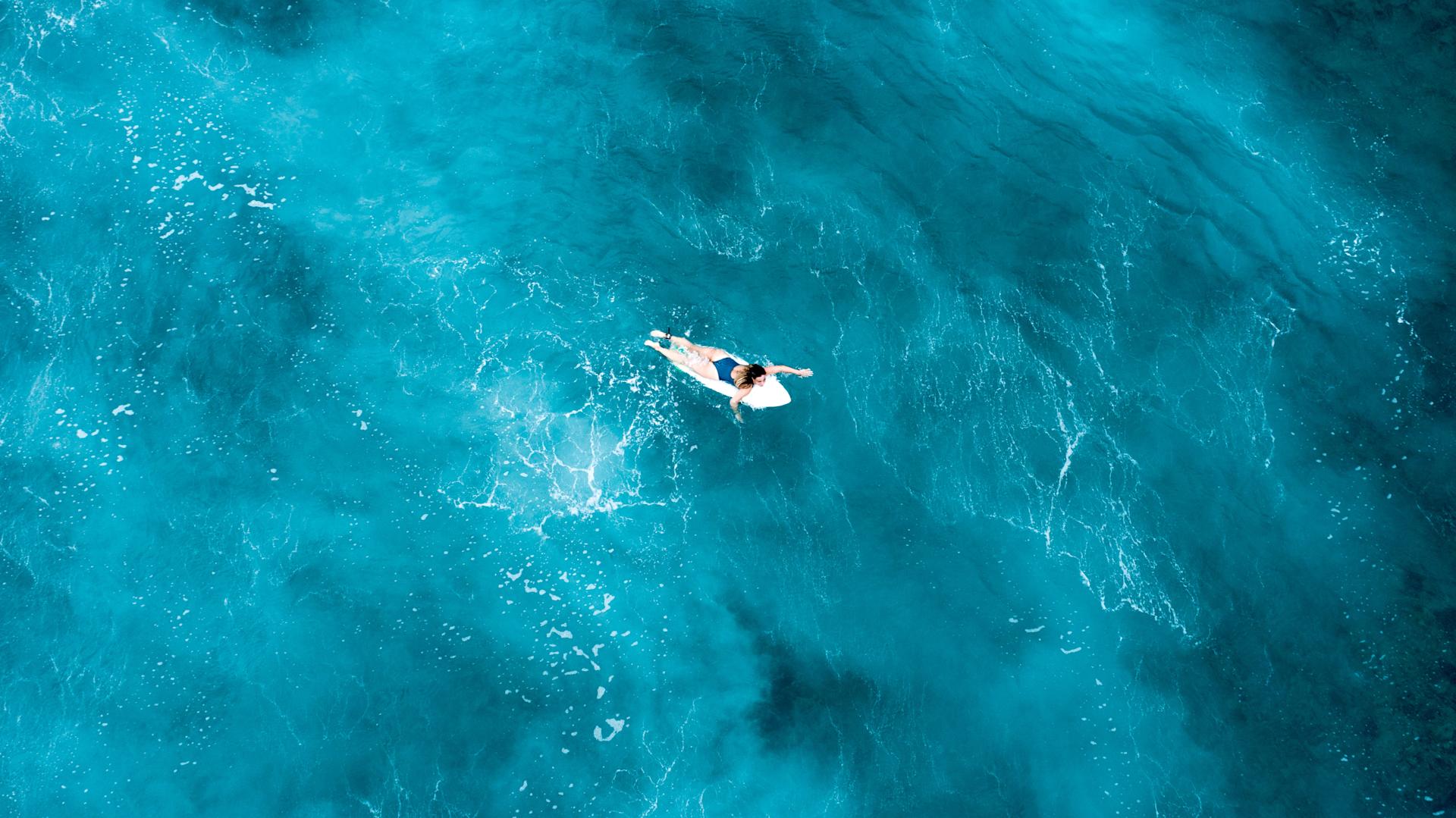 Surfer paddling Maldives