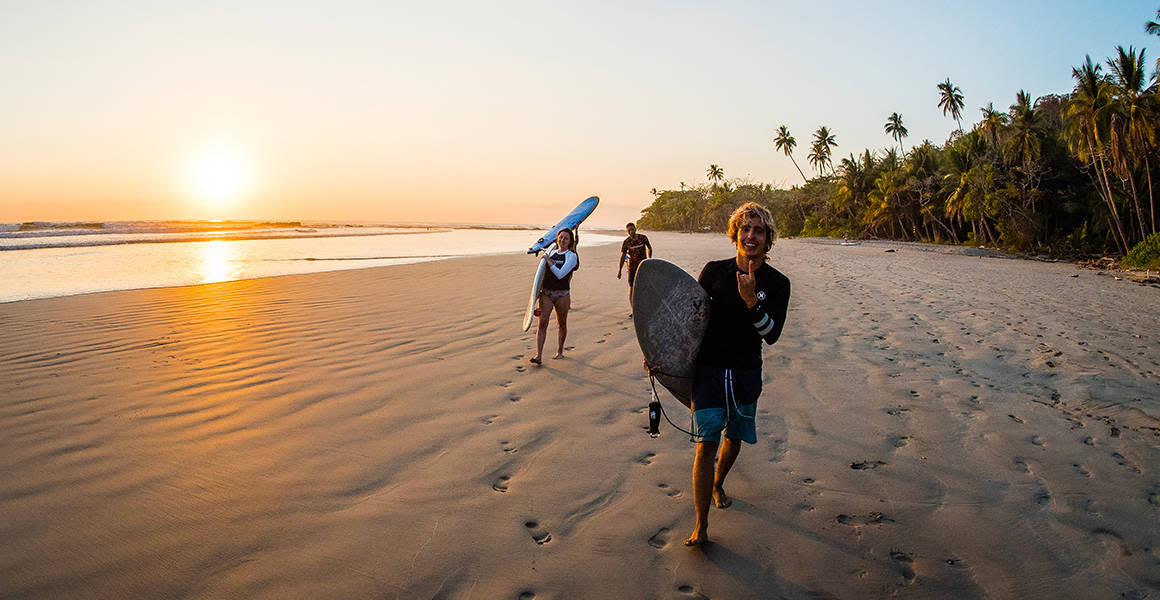 surfers at the beach sunset costa rica