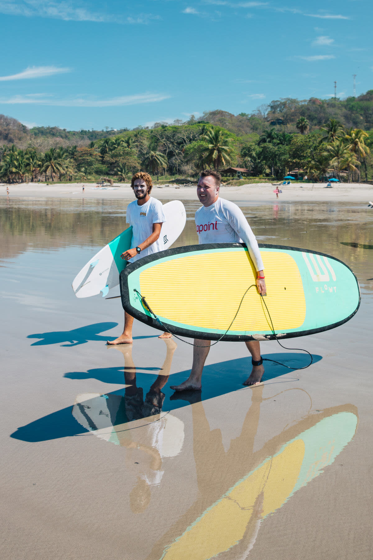 Surfers walking with the board on the beach