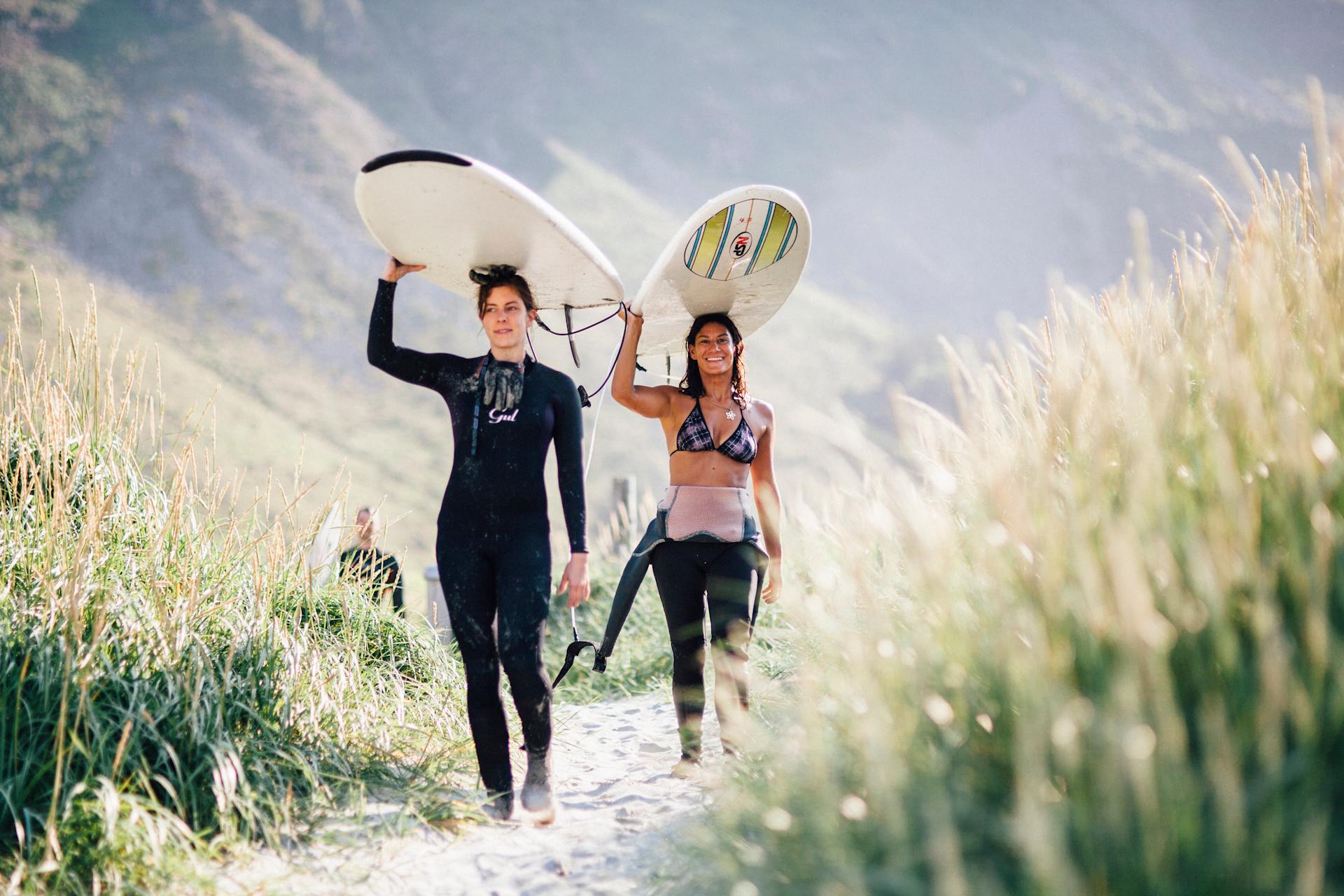 Girls walking with surfboards on their heads