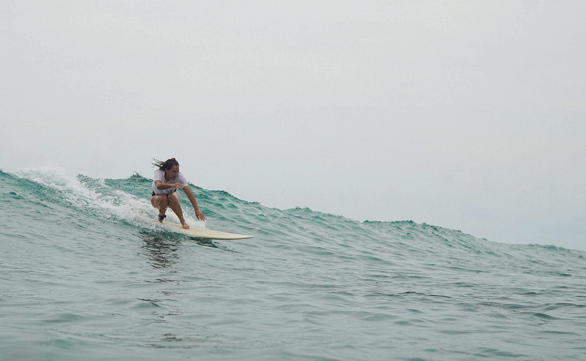 Surfer kneeing on a wave