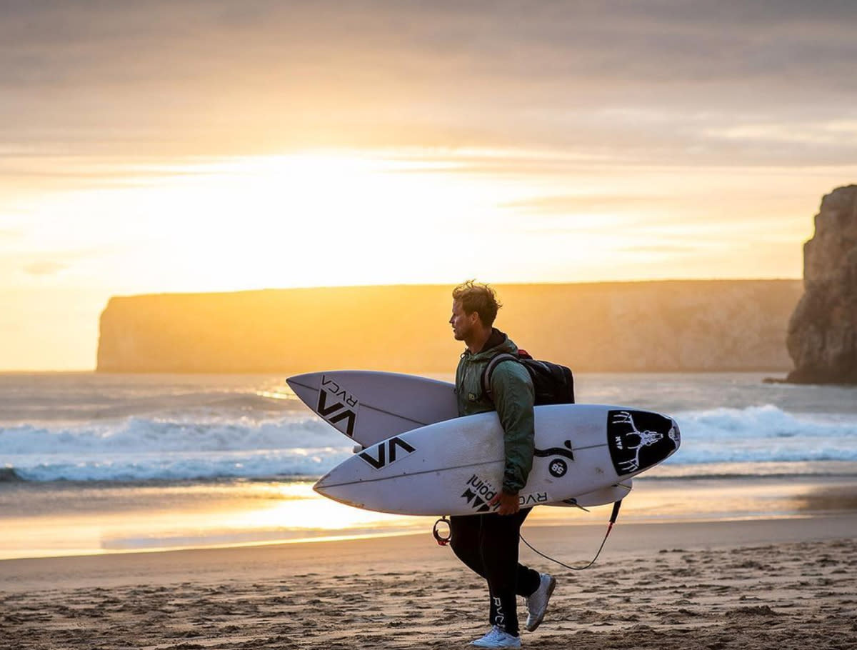 Marlon at the beach with a board
