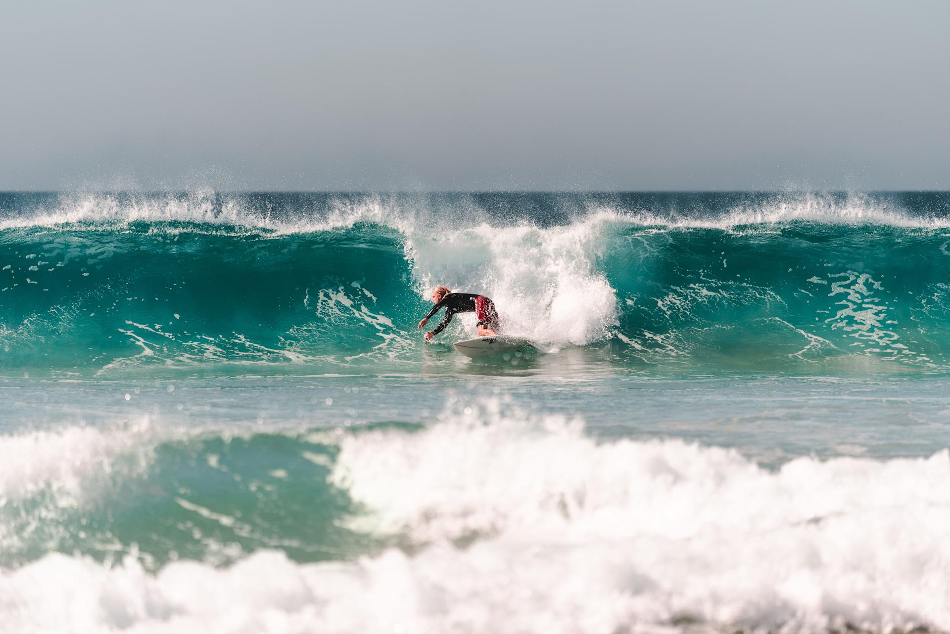 Surfer performing a bottom turn on a wave