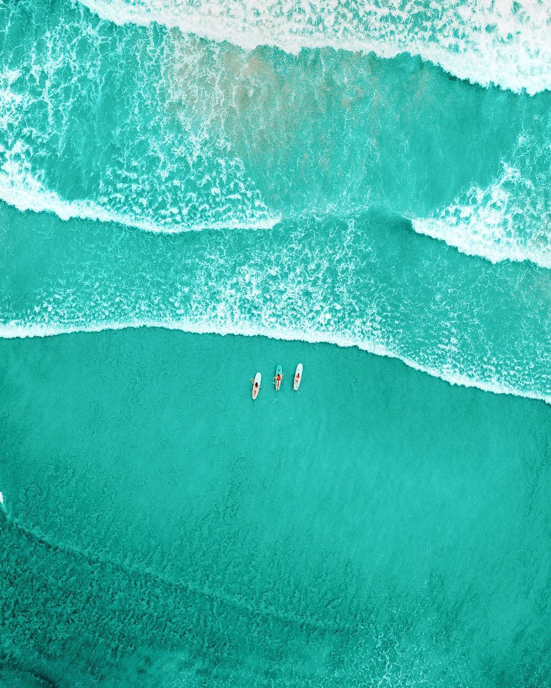 Drone shot of surfers in turquoise water